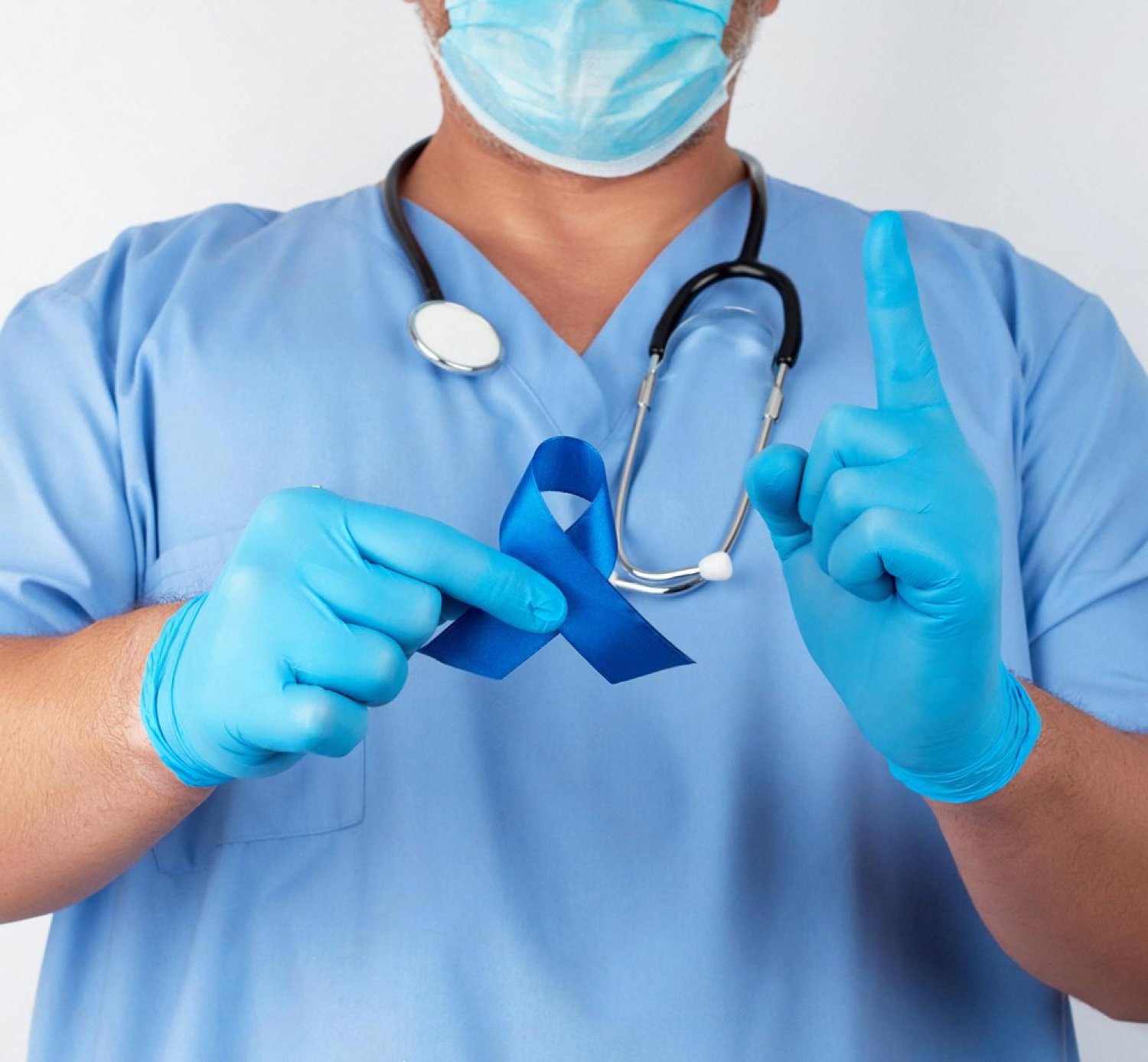 Doctor in scrubs and gloves holding a blue colorectal cancer awareness ribbon